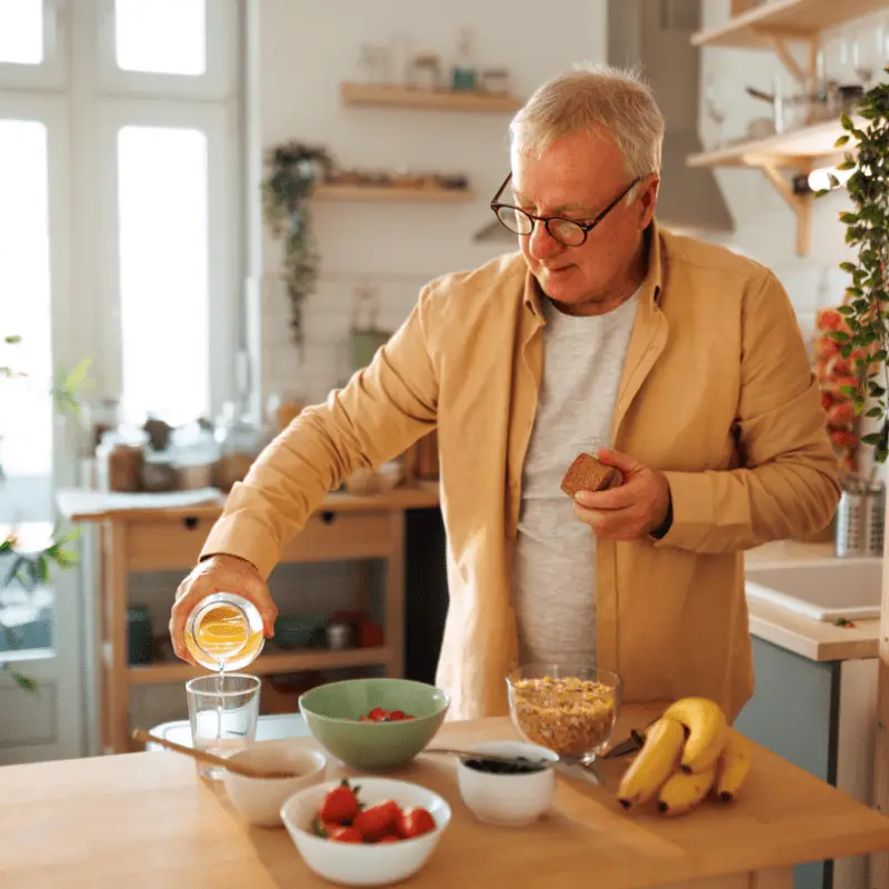 a man pouring a glass of juice into a bowl of cereal