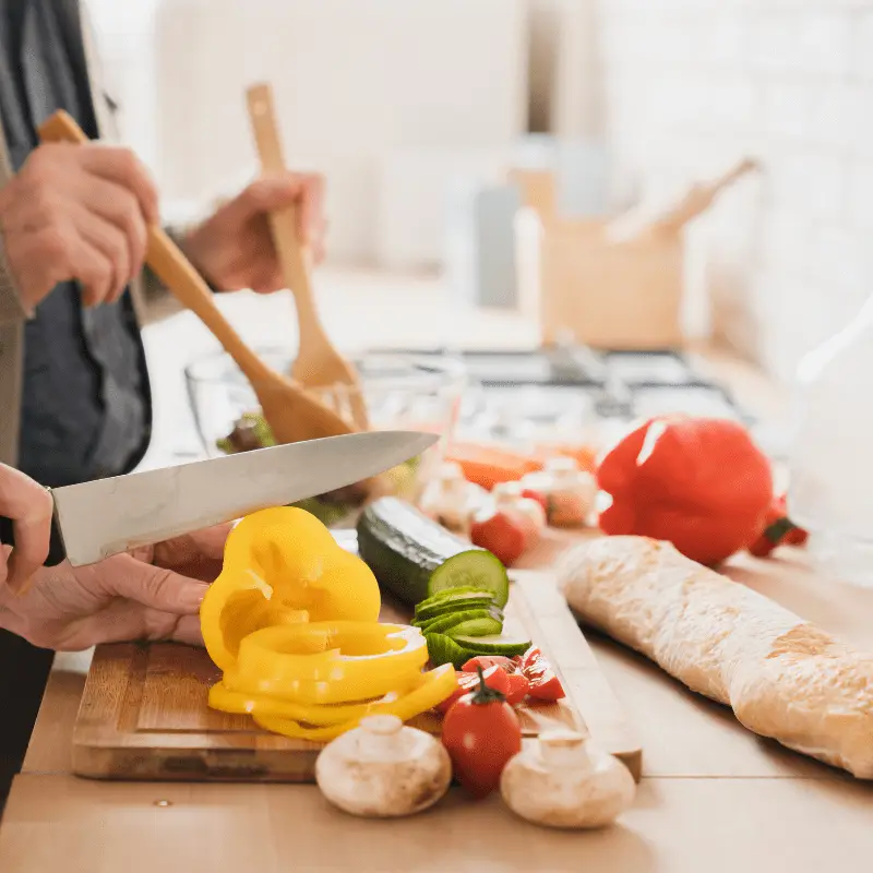 a person cutting vegetables on a cutting board