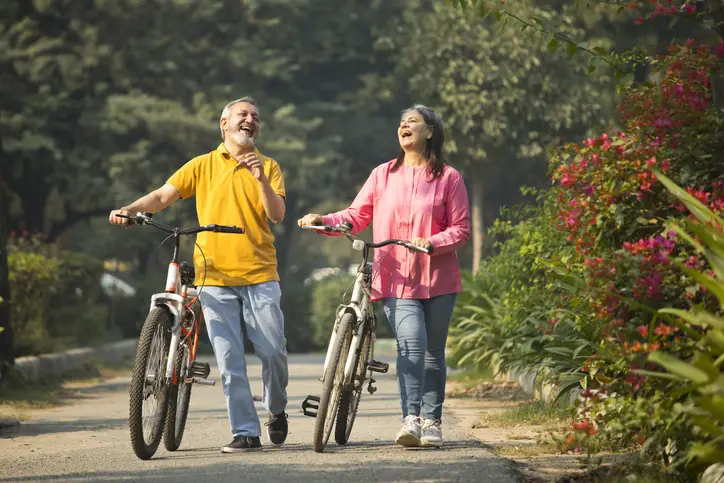 a man and woman walking with bicycles