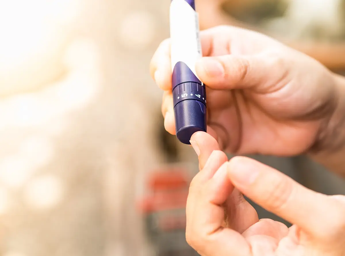 a person using a lancet to check blood sugar level